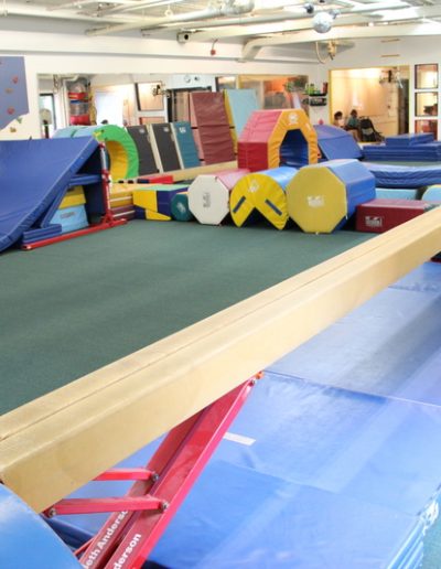 A gymnastics room perfect for toddler gyms and kid parties, featuring a trampoline and other equipment. Ideal for hosting fun-filled birthday parties.